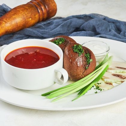 Борщ с говядиной и сметаной подаётся с пампушками и салом